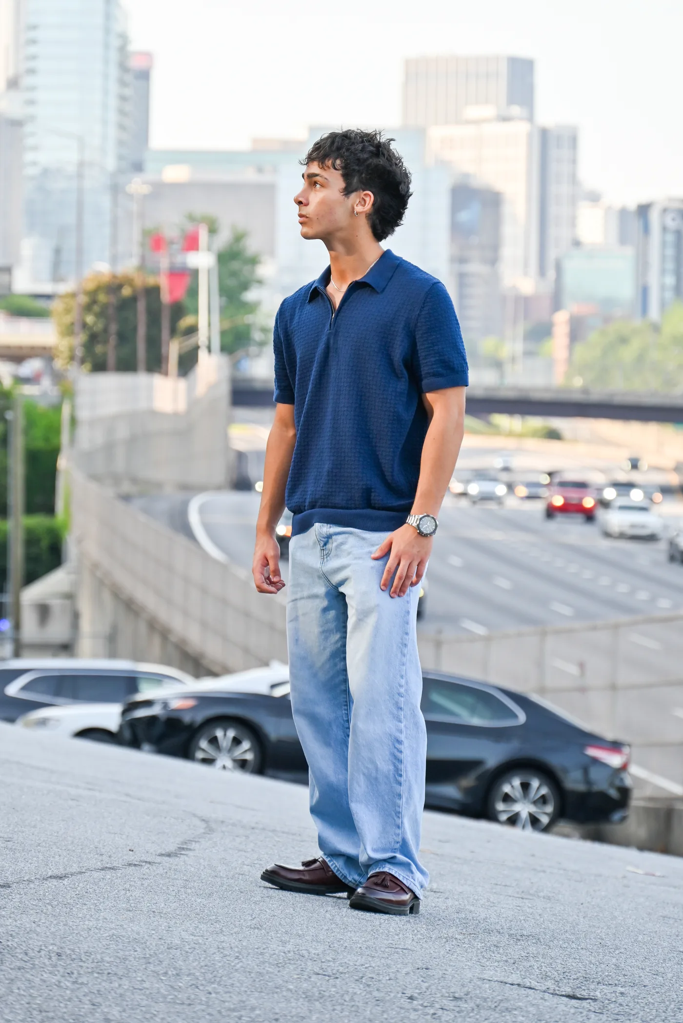 A client standing on a rooftop parking deck with the Atlanta skyline behind him