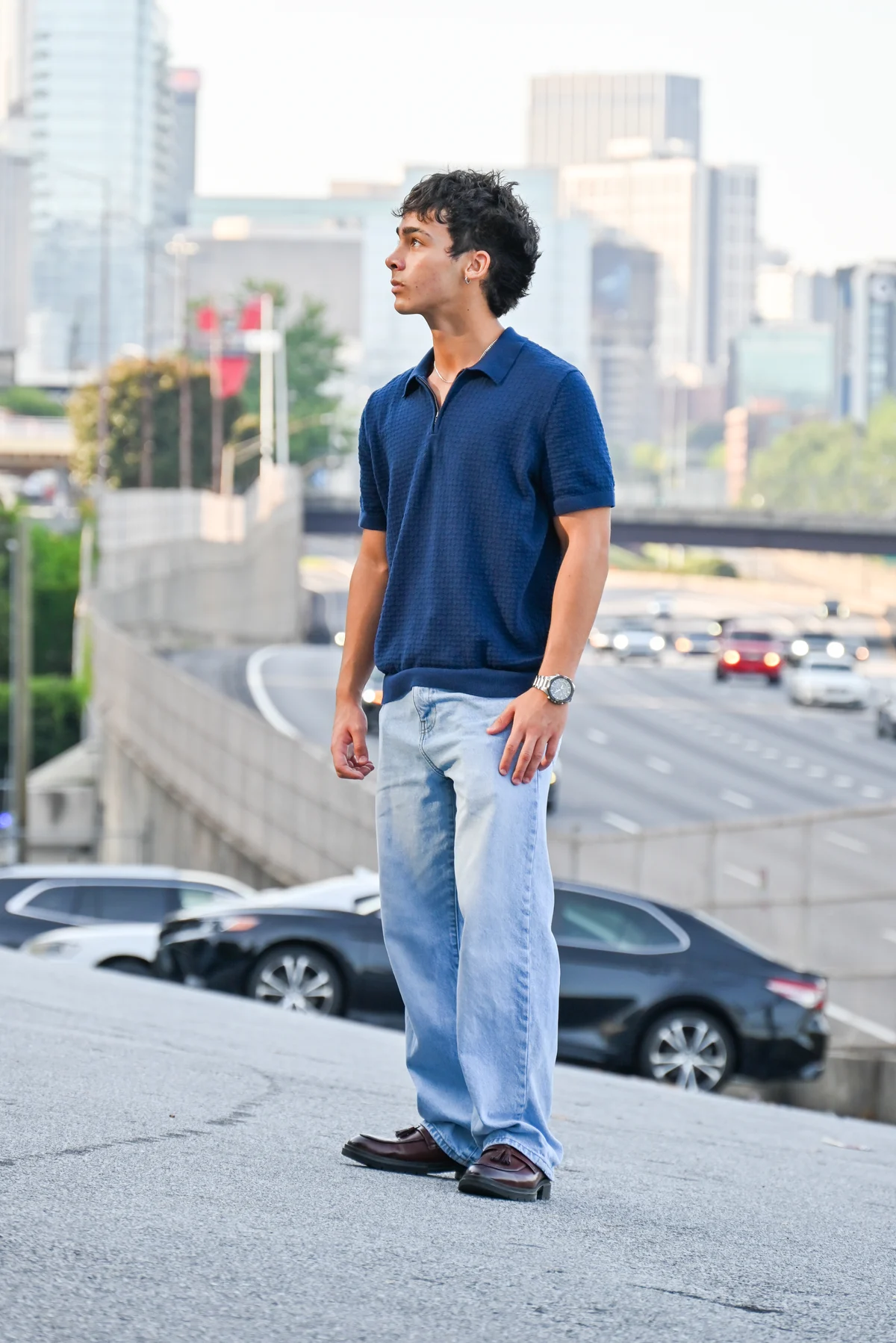 A client in a navy polo standing above the Atlanta skyline at golden hour